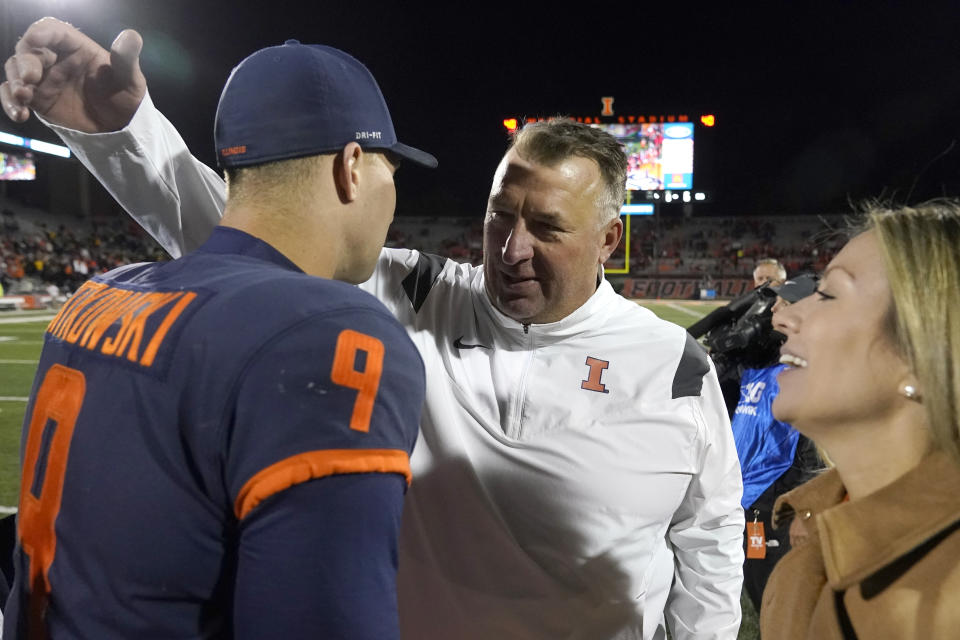Illinois head coach Bret Bielema hugs quarterback Artur Sitkowski as Bielema's wife Jennifer Hielsberg watches after the team's 9-6 win over Iowa in an NCAA college football game Saturday, Oct. 8, 2022, in Champaign, Ill. (AP Photo/Charles Rex Arbogast)