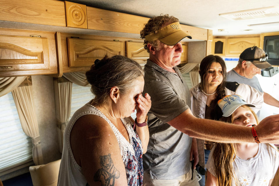 Kimberly Price wipes tears from her eyes while receiving a donated motorhome from EmergencyRV.org founder Woody Faircloth, center, on Sunday, Sept. 5, 2021, in Quincy, Calif. (AP Photo/Noah Berger)