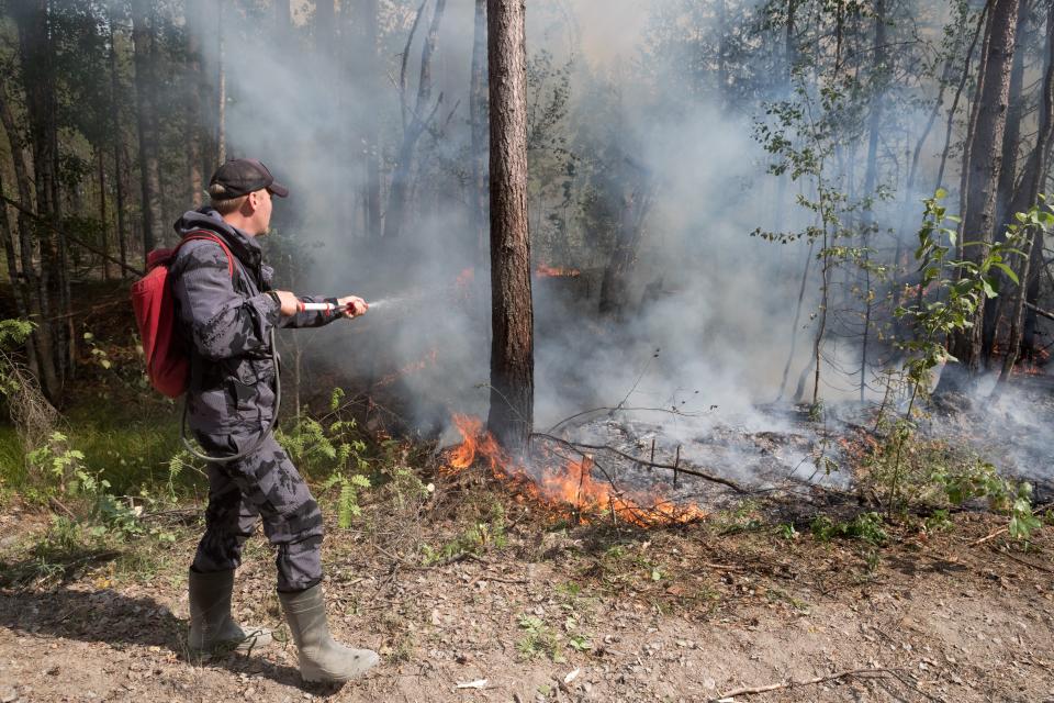 A firefighting crew mops up spot fires near the Syamozero Lake in Pryazhinsky District of the Republic of Karelia, about 700 km.(438 miles) south-west of Moscow, Russia on Wednesday, July 21, 2021. Volunteers have helped in Karelia as well. Anna Gorbunova, coordinator with the Society of Volunteer Forest Firefighters that focuses on the Ladoga Skerries national park in Karelia, told The Associated Press last week that the blazes there this year are the biggest since 2008. (AP Photo/Ilya Timin)