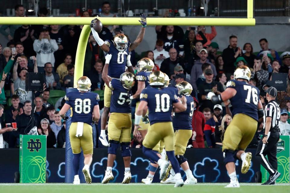 Notre Dame wide receiver Deion Colzie (0) celebrates with teammates after scoring a touchdown against Navy during the second half of an NCAA college football game in Dublin, Ireland, Saturday, Aug. 26, 2023. (AP Photo/Peter Morrison)