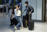 Karen Tyler runs to hug her son Jonathan, who she's not seen for over a year and a half as he arrives on a flight from Houston, Texas, in the U.S., at Terminal 5 of Heathrow Airport in London, Monday, Aug. 2, 2021. Travelers fully vaccinated against coronavirus from the United States and much of Europe were able to enter Britain without quarantining starting today, a move welcomed by Britain's ailing travel industry. (AP Photo/Matt Dunham)