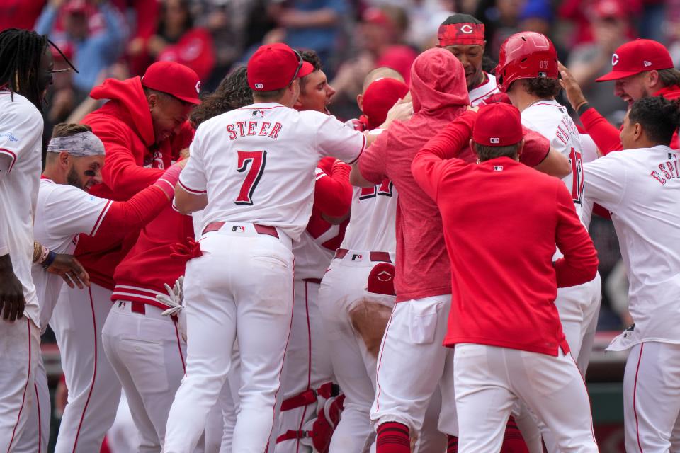 The Cincinnati Reds celebrate a walk-off home run by first baseman Christian Encarnacion-Strand (33) in the ninth inning of a baseball game against the Washington Nationals, Sunday, March 31, 2024, at Great American Ball Park in Cincinnati.