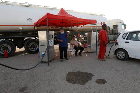 Employee of the state fuel distribution company, Brega, fills a car in Tripoli