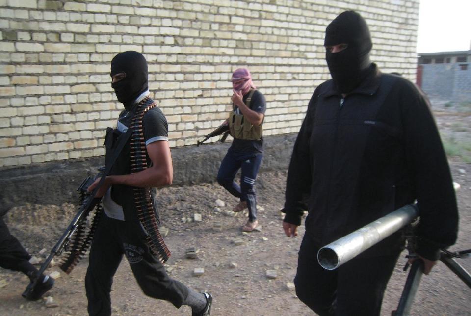 In this Monday, April 28, 2014 photo, masked anti-government gunmen move with their weapons as they patrol in Fallujah, Iraq. Al-Qaida-linked fighters and their allies seized the city of Fallujah and parts of the Anbar provincial capital Ramadi in late December after authorities dismantled a protest camp. Like the camp in the northern Iraqi town of Hawija whose dismantlement in April sparked violent clashes and set off the current upsurge in killing, the Anbar camp was set up by Sunnis angry at what they consider second-class treatment by the Shiite-led government. (AP Photo)