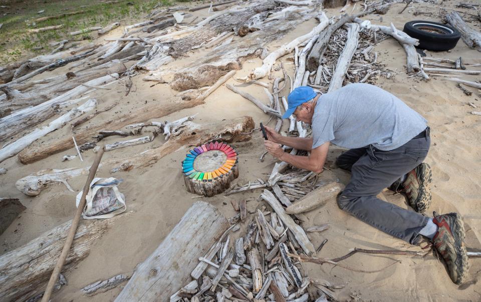 Artist Al Gorman photographs a display of cigarette lighters he's found at the Falls of the Ohio. July 23, 2022