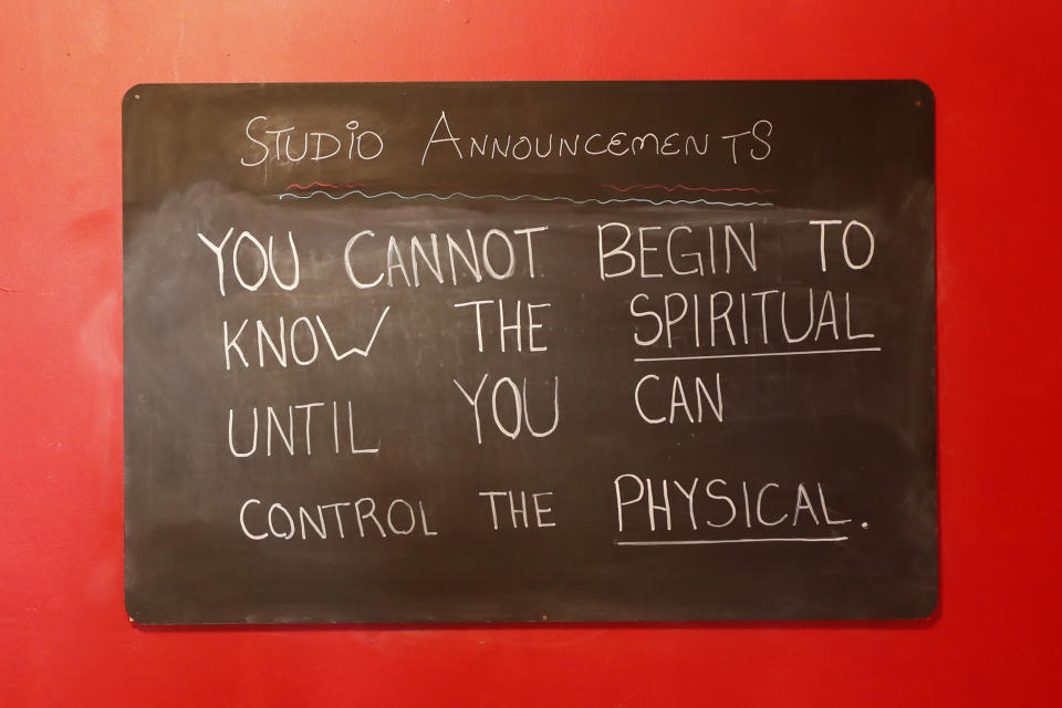 In this April 1, 2020, photo, a sign greets members inside Naveed Abidi's Bikram Yoga West. Tipped off by several residents who disagreed with it being an essential health and wellness center, the city shut it down last week in Chicago. "It was not like an act of rebellion or anything," said Abidi, who faces a fine of up to $10,000. "If we were naughty with the government's order, then we're very, very sorry. We're not here to cause problems, we're here to practice our poses." (AP Photo/Charles Rex Arbogast)