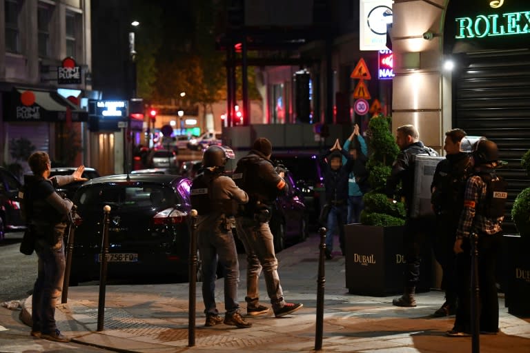 Police check passersby near the Champs Elysees in Paris after a shooting which left one officer dead and two wounded