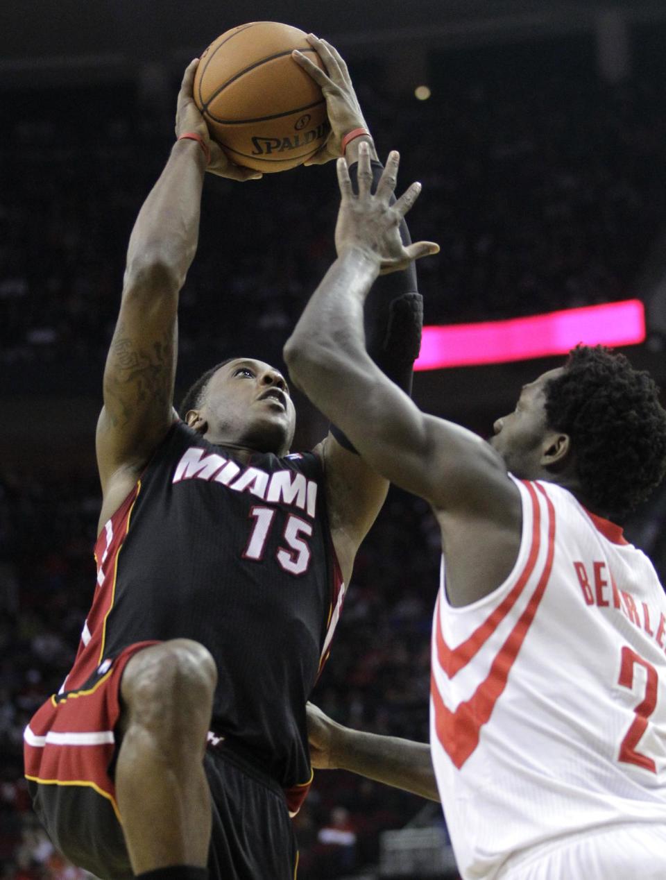 Miami Heat guard Mario Chalmers (15) shoots over Houston Rockets guard Pat Beverly (2) during the first quarter of an NBA basketball game, Tuesday, March 4, 2014, in Houston. (AP Photo/Patric Schneider)