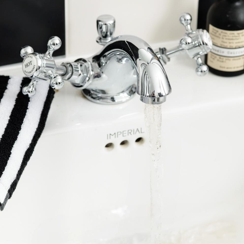 A bathroom sink with a running tap