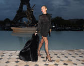 <p>Wearing a black mini dress and heels, Moss strikes a pose using her black fur coat as an accessory. </p>