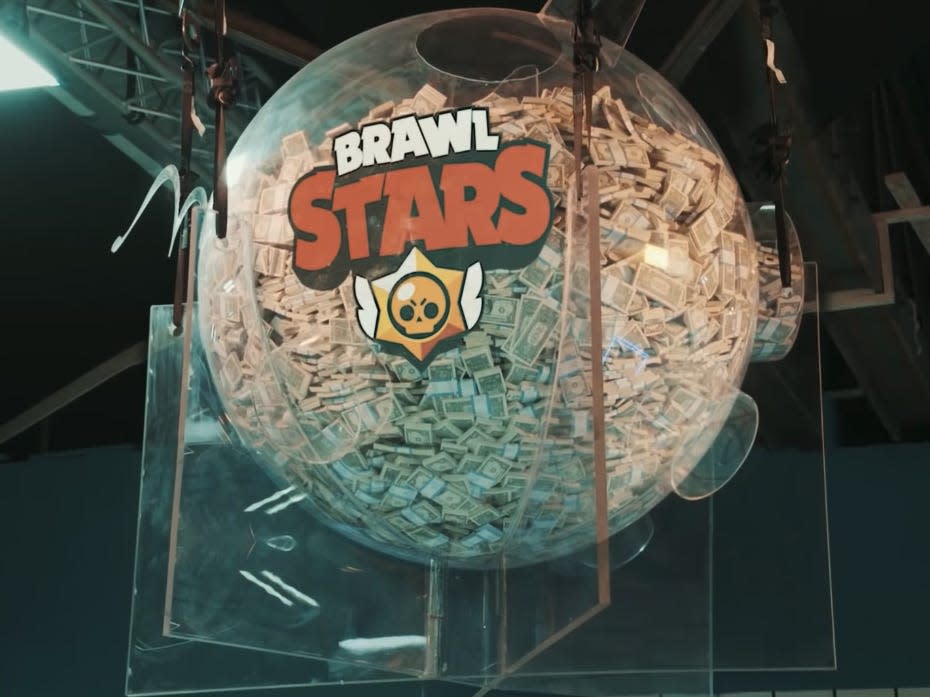 a plastic pig filled with dollar bills that reads "brawl stars" from mr beast's squid game recreation video