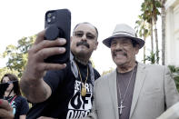 Albert Roman Jr., left, takes a photo with actor Danny Trejo who spoke at the recovery rally about overcoming drug addiction, during a stop of the 2022 Mobile Recovery National Bus tour at the Capitol in Sacramento, Calif. Sept. 7, 2022. Across the country, people in recovery and relatives of those killed by opioid overdoses are pressing for roles in determining how billions in opioid settlement money will be used. That push is one of the missions of the monthlong nationwide bus tour. Through counseling and a desire to have a better life Roman Jr. has worked to overcome a 30 year drug and alcohol addiction. (AP Photo/Rich Pedroncelli)