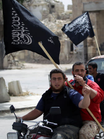 Men on motorbike carry Nusra Front flags as they tour in the rebel-controlled area of Maaret al-Numan town in Idlib province, Syria, May 13, 2016. REUTERS/Khalil Ashawi