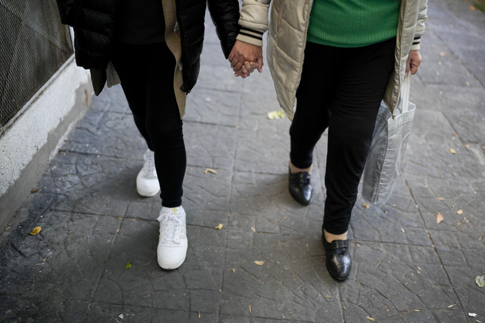 Ana Laporta, right, and Cecilia Olzack hold hands as they walk to their homes after taking a music class at the Caballito and Villa Crespo, a recreational day center for retirees, in Buenos Aires, Argentina, Thursday, April 13, 2023. With inflation at 7.7% in March, keeping the year-on-year measurement above 100%, millions of retirees face the dilemma of whether to eat, take medication or pay the rent since their pensions do not cover a third of their bills. (AP Photo/Natacha Pisarenko)