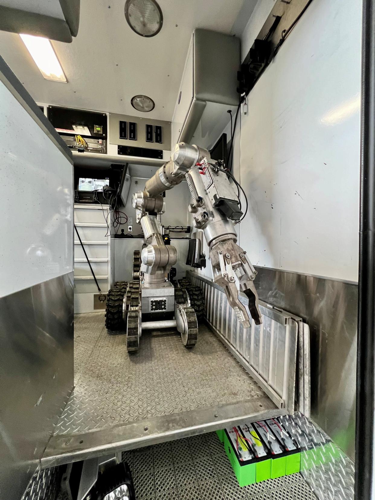 The Salem bomb squad's Spartan robot partially blocks the doorway of its response vehicle. The 530-pound bomb disposal robot has to be offloaded over the steps using the portable aluminum ramps leaning against the wall.