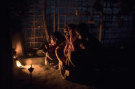 <p>Rohingya Muslim refugees who have been living in Bangladesh for over a year sit by a fire in a more established shelter in a refugee camp on Sept. 8, 2017 in Gundum, Bangladesh. (Photo: Dan Kitwood/Getty Images) </p>