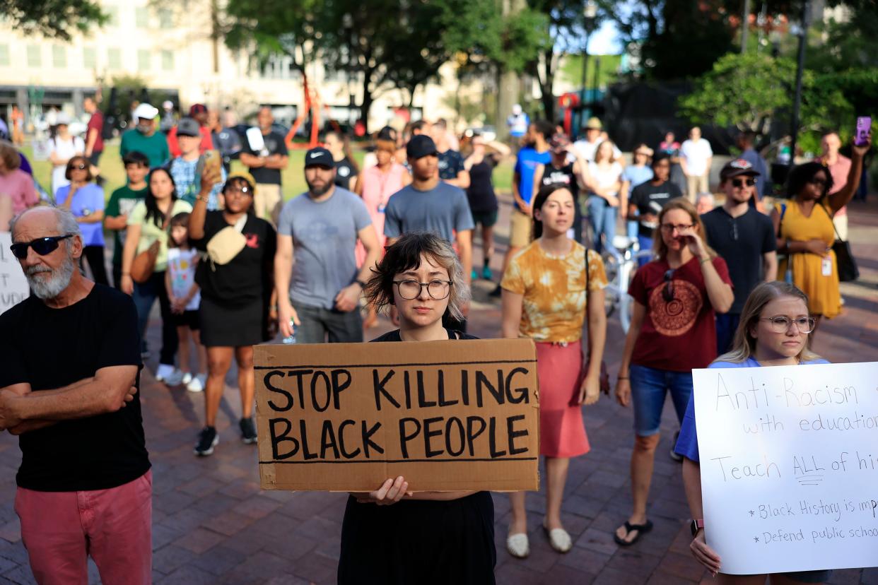 Jacqui Burns holds up a sign Monday, Aug. 28, 2023 at James Weldon Johnson Park in downtown Jacksonville, Fla. In light of the recent shooting at the Dollar General, that left three African-American individuals dead, hundreds came out to rally against white supremacy.