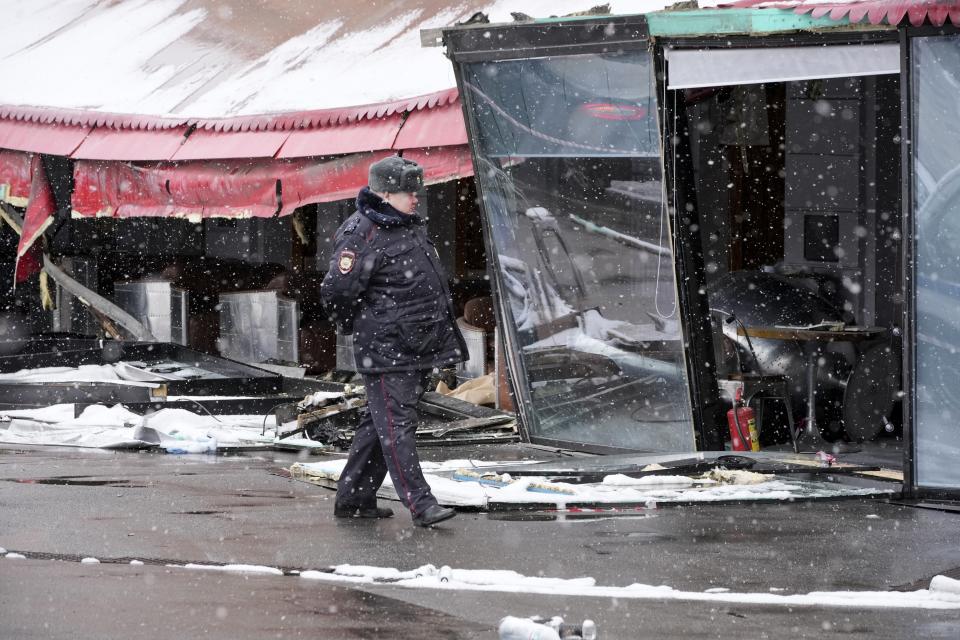 A police officer walks at the site of an explosion at the "Street Bar" cafe in St. Petersburg, Russia, Monday, April 3, 2023. Russian police have arrested a woman suspected of delivering a bomb that killed well-known military blogger Vladlen Tatarsky on Sunday. Over 30 people were wounded by the blast. Russian news reports said the bomb was hidden in a bust of the blogger that the suspect had given to him as a gift just before the explosion. (AP Photo/Dmitri Lovetsky)