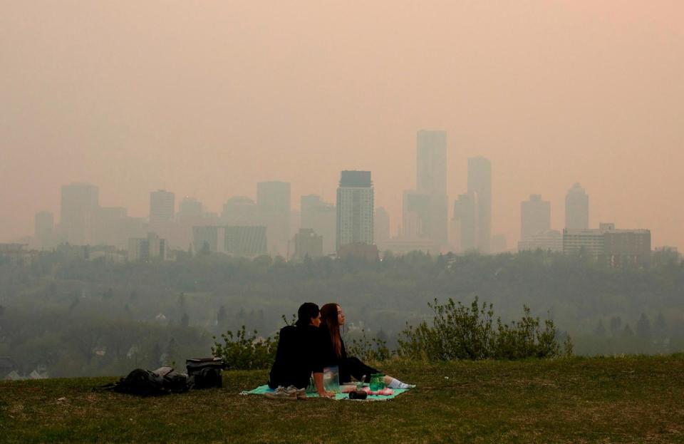 PHOTO: Smoke from wildfires blankets the city as a couple has a picnic in Edmonton, Alberta, May 11, 2024.  (Jason Franson/AP)
