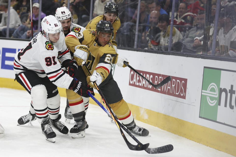 Chicago Blackhawks center Frank Nazar (91) attempts to steal the puck from Vegas Golden Knights defenseman Alec Martinez (23) during the third period of an NHL hockey game Tuesday, April 16, 2024, in Las Vegas. (AP Photo/Ian Maule)