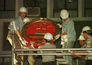 FILE - In this July 1, 1997, file photo, workers prepare to place a huge new Chinese governmental emblem on the wall of the Central Government Office in Hong Kong following the British handover of Hong Kong to China. Hong Kong has been living on borrowed time ever since the British made it a colony nearly 180 years ago, and all the more so after Beijing took control in 1997, granting it autonomous status. A national security law approved by China's legislature on May 28, 2020 is a reminder that the city's special status is in the hands of Communist Party leaders who have spent decades building their own trade and financial centers to take Hong Kong's place. (AP Photo/Dave Smith, File)