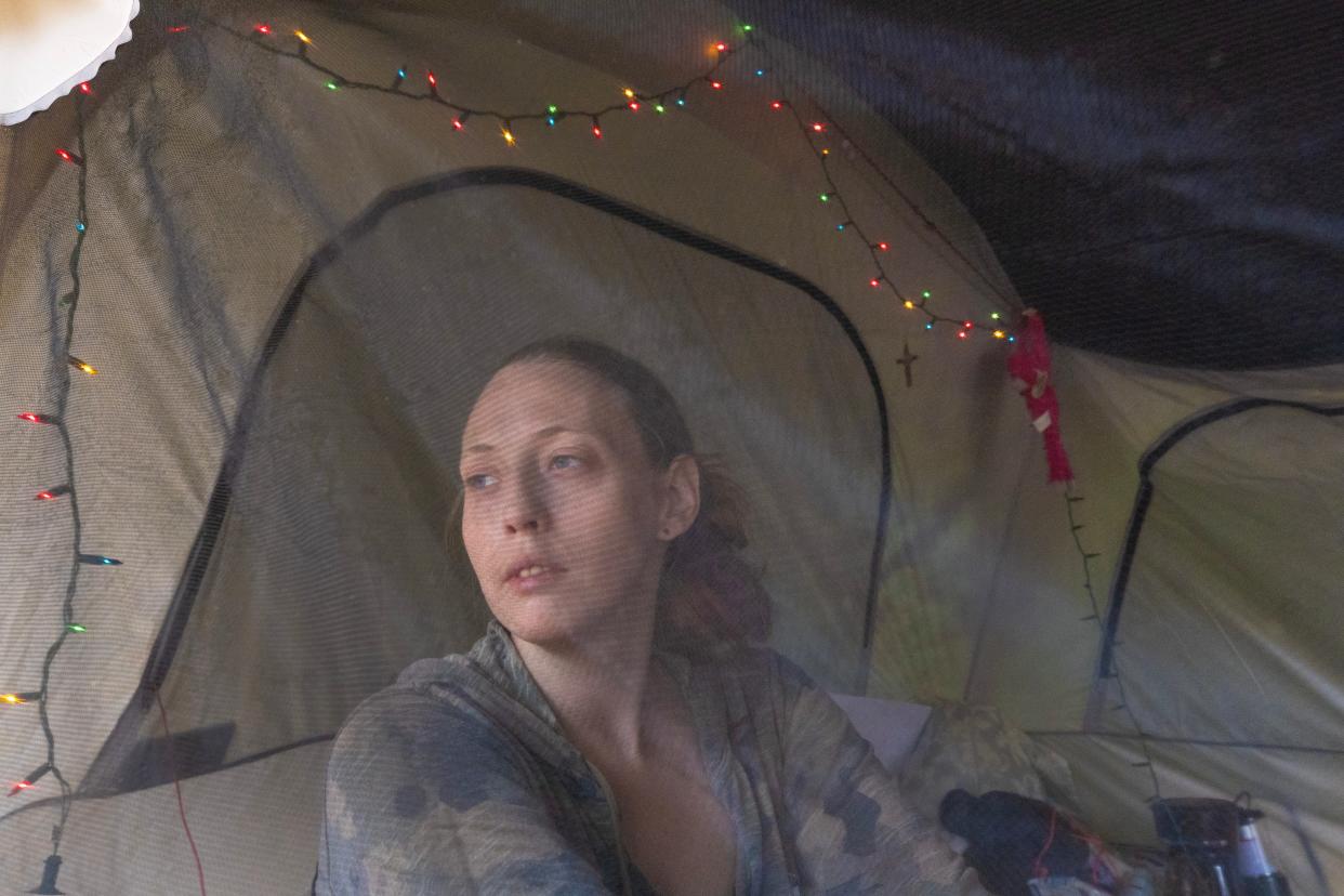 Kayla looks at the warm weather outside as she takes a break from cleaning. The homeless in the camp in the Toms River woods enjoy the nice weather when they have it and take to their tents to wait out the bad as it comes. As the first warmer days of spring arrive, the homeless pull back the plastic coverings to let in some fresh air.