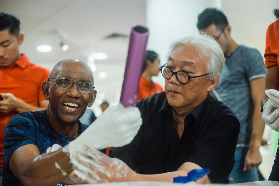 C. Kunalan’s hand gets cast by artist Baet Yeok Kuan during the making of the art piece to commemorate the former sprinter’s career. PHOTO: Singapore Sports Hub