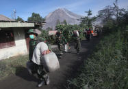 <p>Indonesian soldiers carry people’s belongings during an evacuation following the eruption of Mount Sinabung in Gamber village, North Sumatra, Indonesia, May 22, 2016. The volcano in western Indonesian unleashed hot clouds of ash on Saturday, killing several villagers, officals said. (Bakkara/AP) </p>