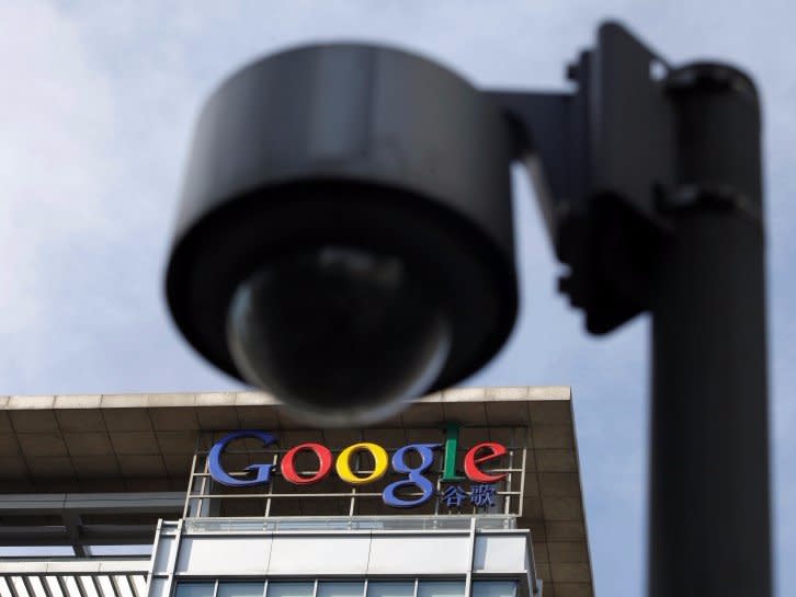 The Google logo is seen on the top of its China headquarters building, behind a road surveillance camera in Beijing March 15, 2010.    REUTERS/Jason Lee