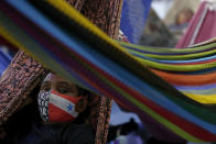 A passenger wears a mask to curb the spread of COVID-19, during a boat trip to the city of Breves, located in the island of Marajo, Para state, on the mouth of the Amazon river, Brazil, Thursday, Dec. 3, 2020. The city of Breves is a hub for river traffic, with boats coming from the cities of Belém, Manaus and Macapá, and a large concentration of passengers who largely do not respect social distancing guidelines to curb the spread of the new coronavirus. (AP Photo/Eraldo Peres)