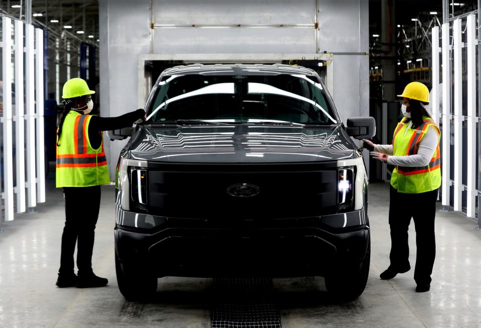 Kelly Jones, left, and Rhonda Cenance, pre-delivery inspectors, look over a 2022 Ford F-150 Lightning inside the plant where it will be built, the Rouge Electric Vehicle Center at the Ford Rouge Plant in Dearborn on Thursday, Sept. 16, 2021.