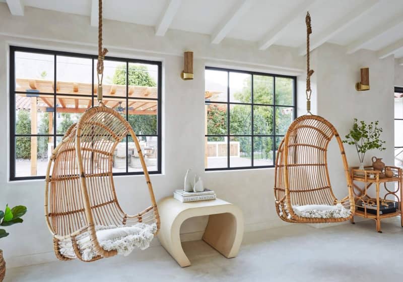Bamboo swings in front of large windows.