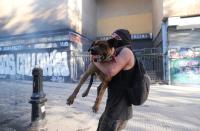 Un manifestante y su perro se refugian durante una protesta contra el gobierno en Santiago, Chile.
