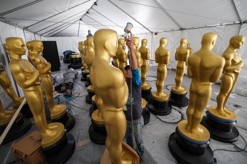 Los Angeles, CA, Thursday, March 9, 2023 - Scenic artist Michael Thomas touches up Oscar statues as work continues on Hollywood Blvd. in preparation for the 95th Academy Awards. (Robert Gauthier/Los Angeles Times)