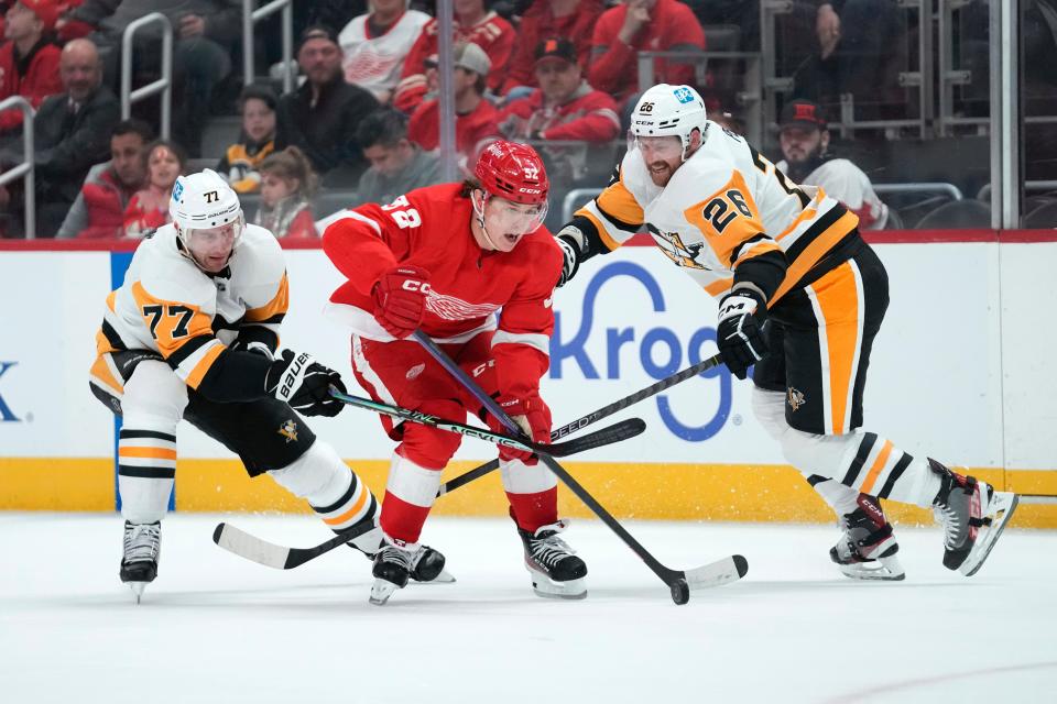 Red Wings right wing Jonatan Berggren skates through Penguins center Jeff Carter, left, and Jeff Petry in the third period of the Wings' 5-1 loss on Saturday, April 8, 2023, at Little Caesars Arena.