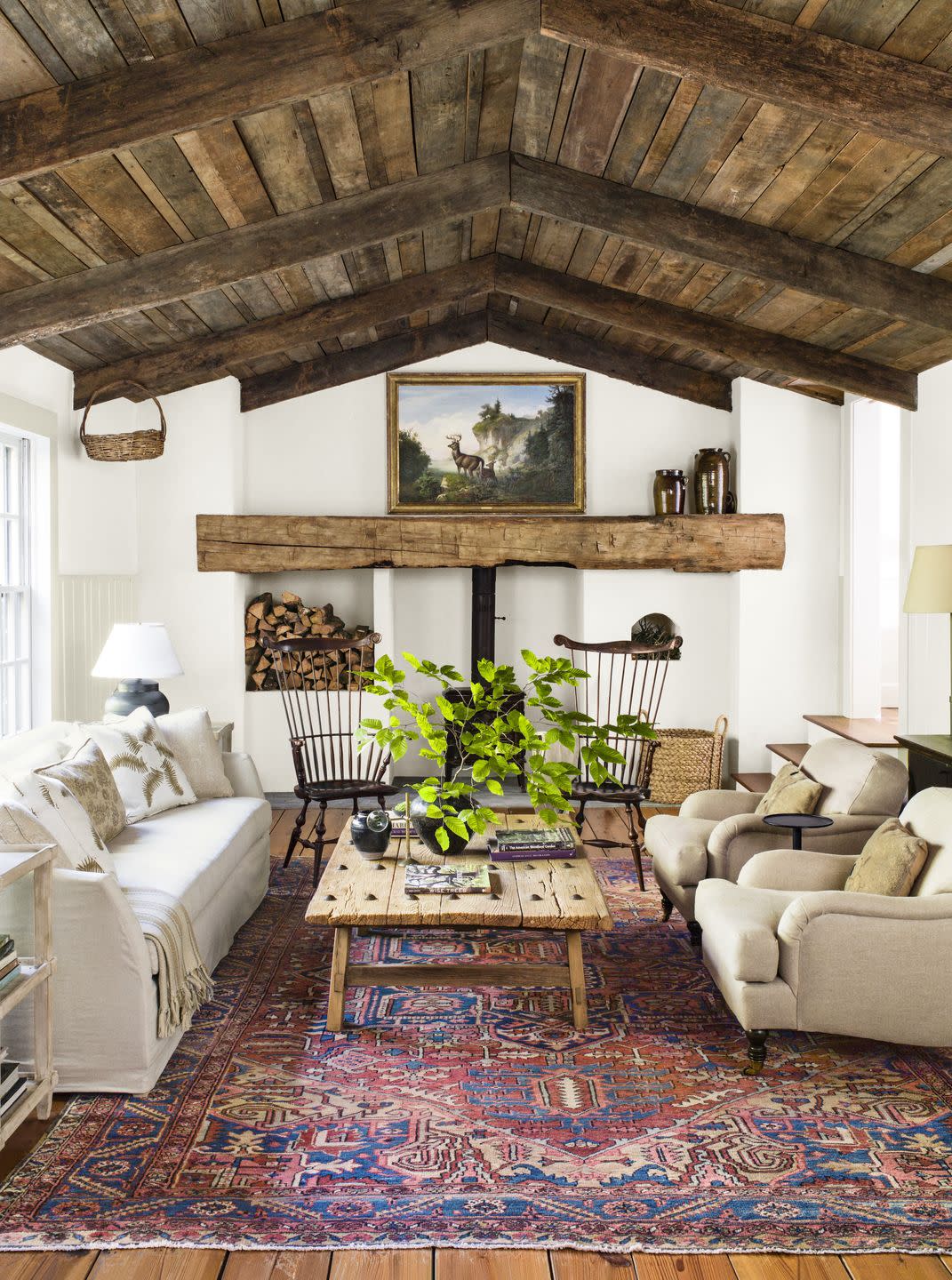 rustic farmhouse living room with neutral upholstery and red patterned rug