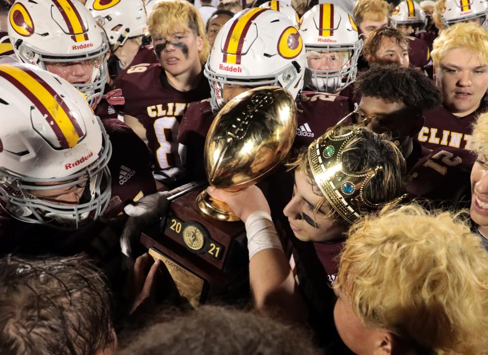 Clinton players celebrate with the Class 4A championship trophy Friday night in Edmond after a 35-0 win against Tuttle.