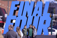 Fans pose with a Final Four logo before a college basketball game during the Final Four round of the NCAA tournament at Lucas Oil Stadium in Indianapolis, Saturday, April 3, 2021. (AP Photo/AJ Mast)