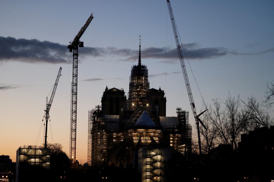 This photograph taken on February 12, 2024, shows the illuminated construction site of Notre-Dame de Paris Cathedral with its rear spire at sunset, in Paris.