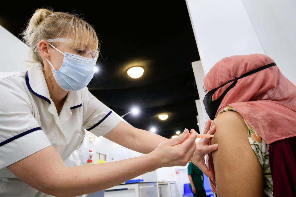 A woman receives an injection of the the Oxford/AstraZeneca coronavirus vaccine at Elland Road vaccine centre in Leeds, as a study shows that people from Asian and minority ethnic (BAME) groups living in deprived communities are more likely to be hesitant about the coronavirus vaccine than those in more affluent areas. Picture date: Friday March 12, 2021.