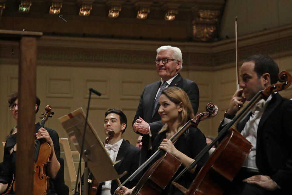 German President Frank-Walter Steinmeier stands onstage with musicians prior to a joint concert of the Boston Symphony Orchestra and Germany's visiting Leipzig Gewandhaus Orchestra, Thursday, Oct. 31, 2019, at Symphony Hall in Boston. (AP Photo/Elise Amendola)