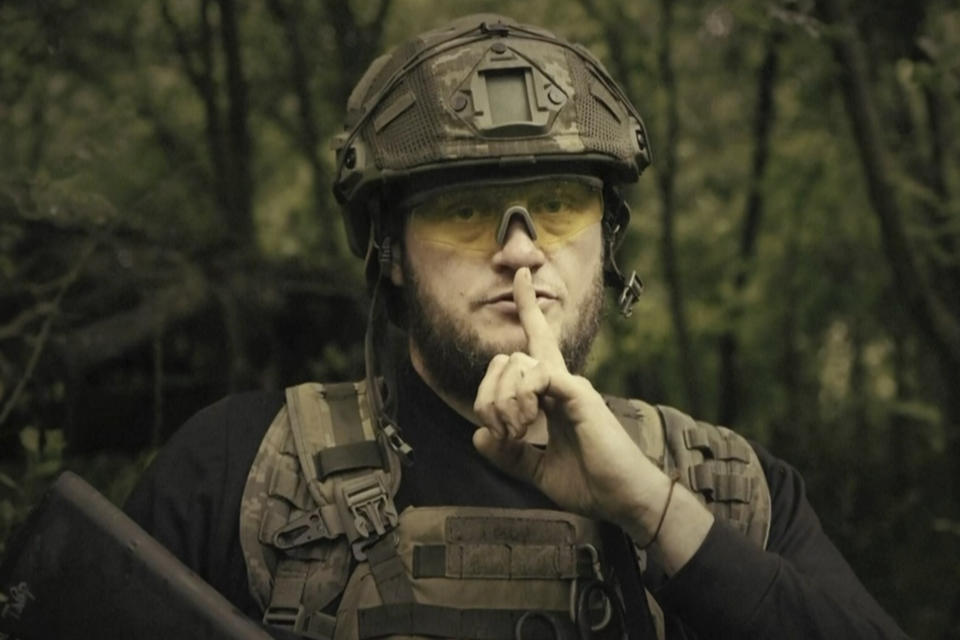 En esta imagen extraída de un video proporcionado por el Ministerio ucraniano de Defensa el domingo 4 de junio de 2023, un soldado ucraniano posa para la cámara con el dedo sobre los labios en un lugar no revelado de Ucrania. Un video publicado por el Ministerio mostraba a militares haciendo gestos de silencio, lo que apuntaba a que no habría un anuncio formal de una posible contraofensiva contra Rusia. El texto que aparecía en pantalla decía "A los planes les encanta el silencio. No habrá anuncio sobre el comienzo". (Ministerio ucraniano de Defensa via AP)