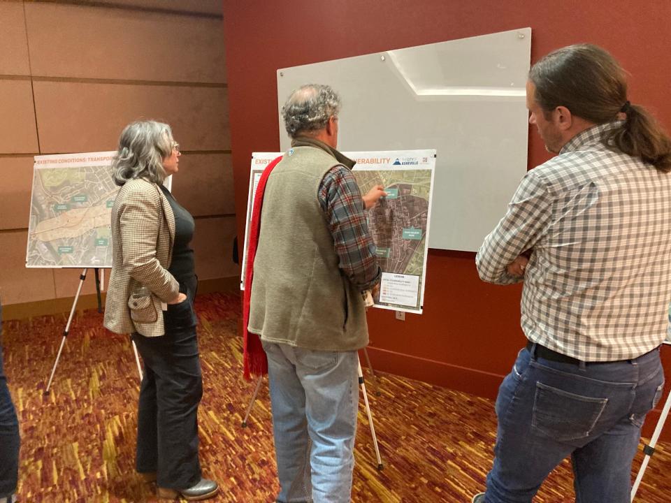 Stephanie Monson Dahl (left), director of Planning and Urban Design, stands in front of a graphic demonstrating the city's Patton Avenue Corridor Feasibility study area at an open house on Nov. 29, 2023.