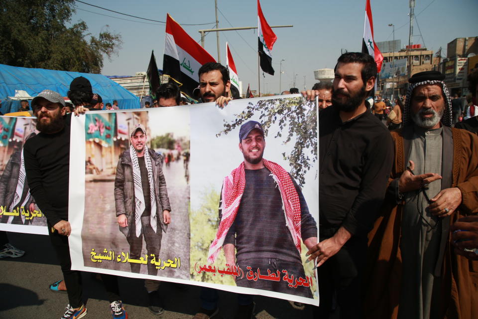 Iraqis hold photos of missing protesters during anti-government protest in Baghdad, Iraq, Sunday, Feb. 23, 2020. There are 25 activists still missing since the protests erupted on Oct. 1, 2019, according to the semi-official Iraqi High Commission for Human Rights. No group has claimed responsibility but activists have blamed the militias. (AP Photo/Khalid Mohammed)