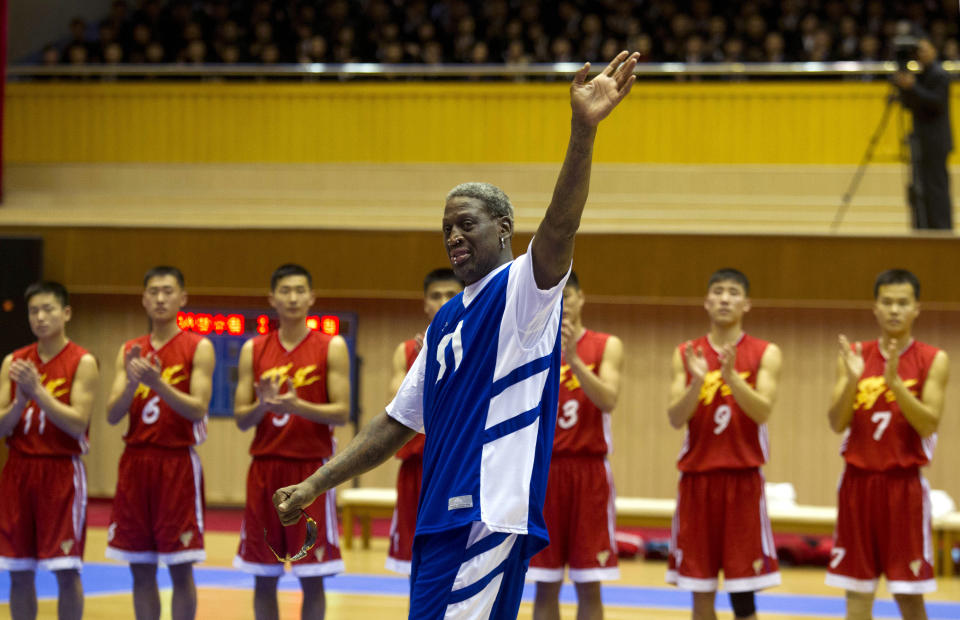 Dennis Rodman waves at North Korean leader Kim Jong Un, seated above in the stands, after singing "Happy Birthday" to him before an exhibition basketball game at an indoor stadium in Pyongyang, North Korea in January 2014.