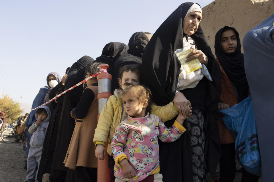 Afghans waiting in long lines for humanitarian aid.