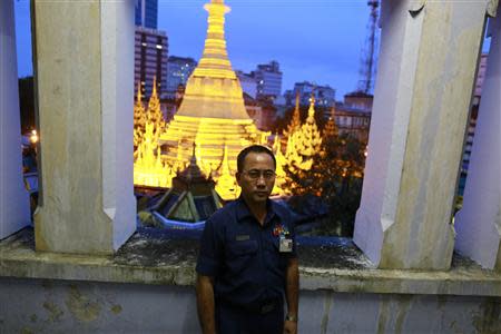 Toe Aung, deputy head of urban planning, poses for a photo at the Yangon City hall, with the lit Sule Pagoda seen behind him, in Yangon, September 5, 2013. REUTERS/Soe Zeya Tun