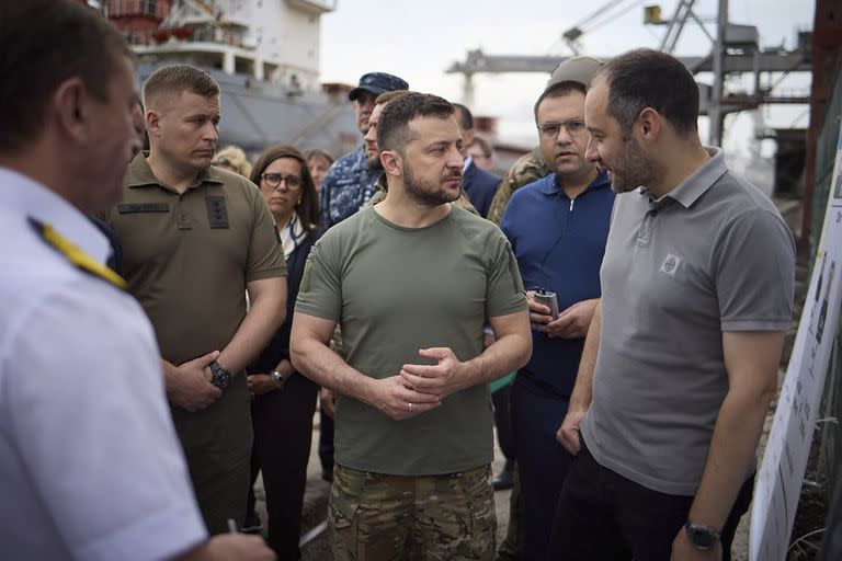 En esta foto distribuida por el Despacho Presidencial de Ucrania, el presidente ucraniano Volodymyr Zelenskyy, centro, rodeado por embajadores y funcionarios de la ONU, visita el puerto de Chornomork durante la carga de cereales en una nave turca, cerca de Odesa, Ucrania, viernes 29 de julio de 2022. (Oficina de Prensa del Despacho Presidencial de Ucrania via AP)