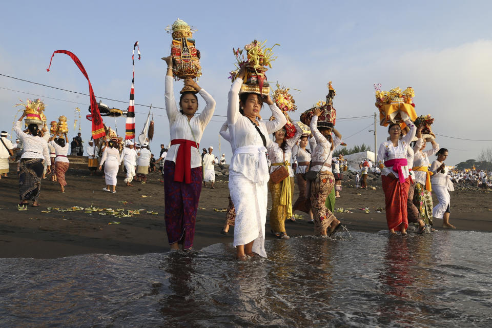 Balinese Hindus participate in a purification ceremony during sunrise on Melasti at Padanggala beach in Bali, Indonesia on Friday, March 8, 2024. Melasti is part of the six-day long Balinese Hindu New Year, where devout perform rituals as an act of symbolic cleansing. (AP Photo/Firdia Lisnawati)
