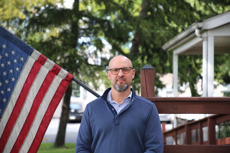 Chris Amato standing in front of a US flag